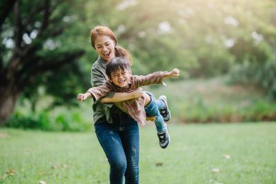 Adult woman and toddler ina a field smiling