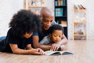 African American father reading a fairly tale fable story for kids at home