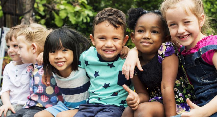 Children smiling with their arms around each other