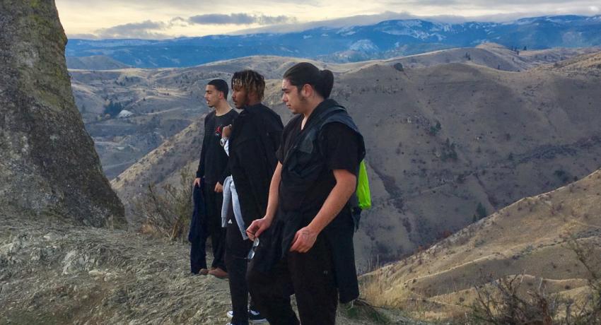 Residents of Canyon View Community Facility on a nature hike stand atop a mountain and look over the landscape. 