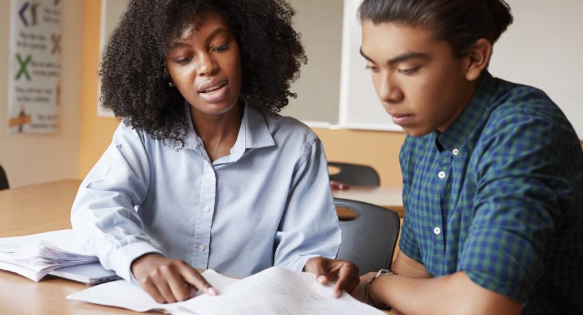 A woman tutoring a young person. 