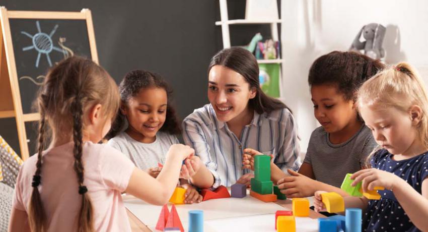 Children and teacher playing with blocks