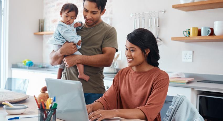 mom, dad, and baby looking at a laptop screen