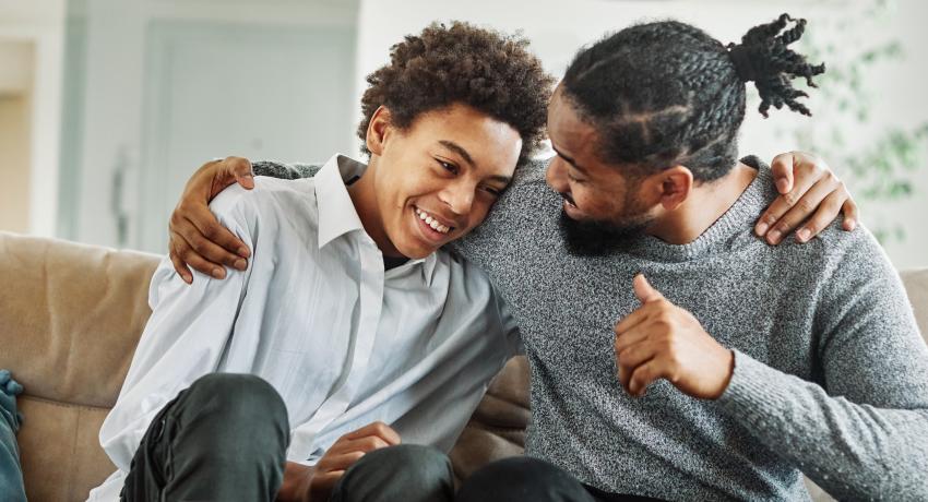 father and son talking and embracing, both happy